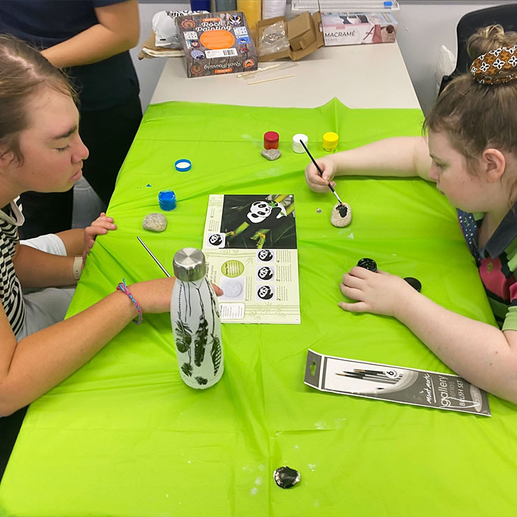 Participants painting rocks using a rock painting kit